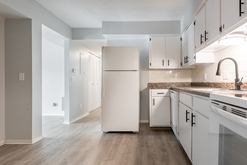 a kitchen with white cabinets and a white refrigerator