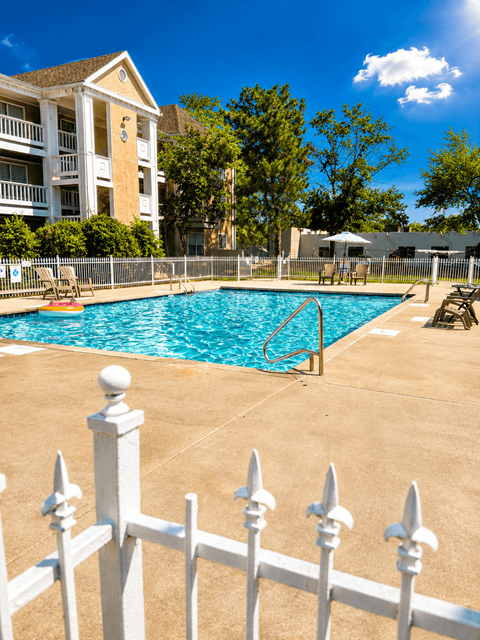 A white fence surrounds a small pool.