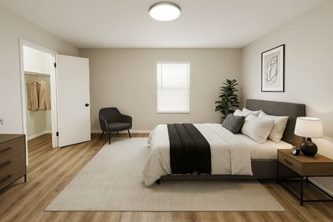 A bedroom with a bed, chair, and a plant.