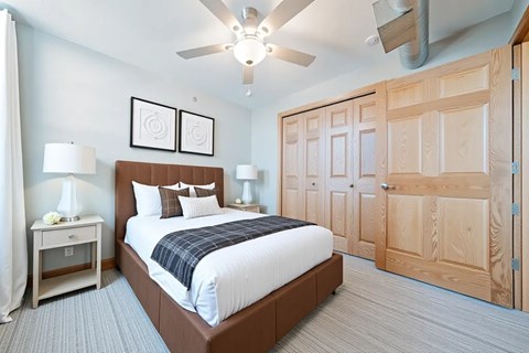 A bedroom with a bed, nightstand, and two lamps.