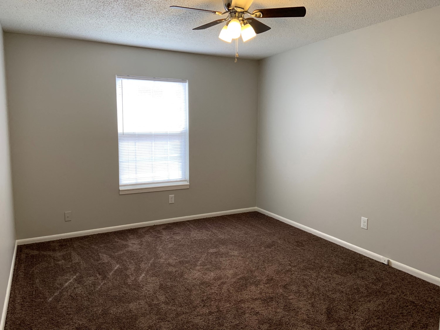 Bedroom with carpet, ceiling fan, and window at Chouteau Heights.