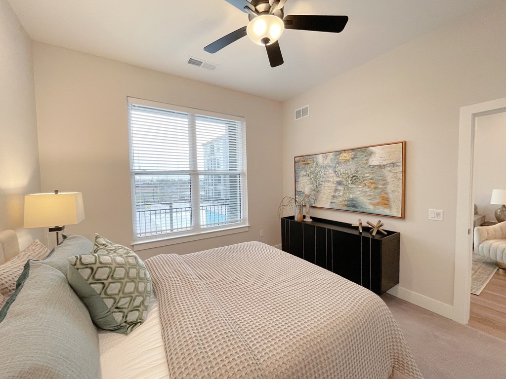 a bedroom with a large bed and a ceiling fan