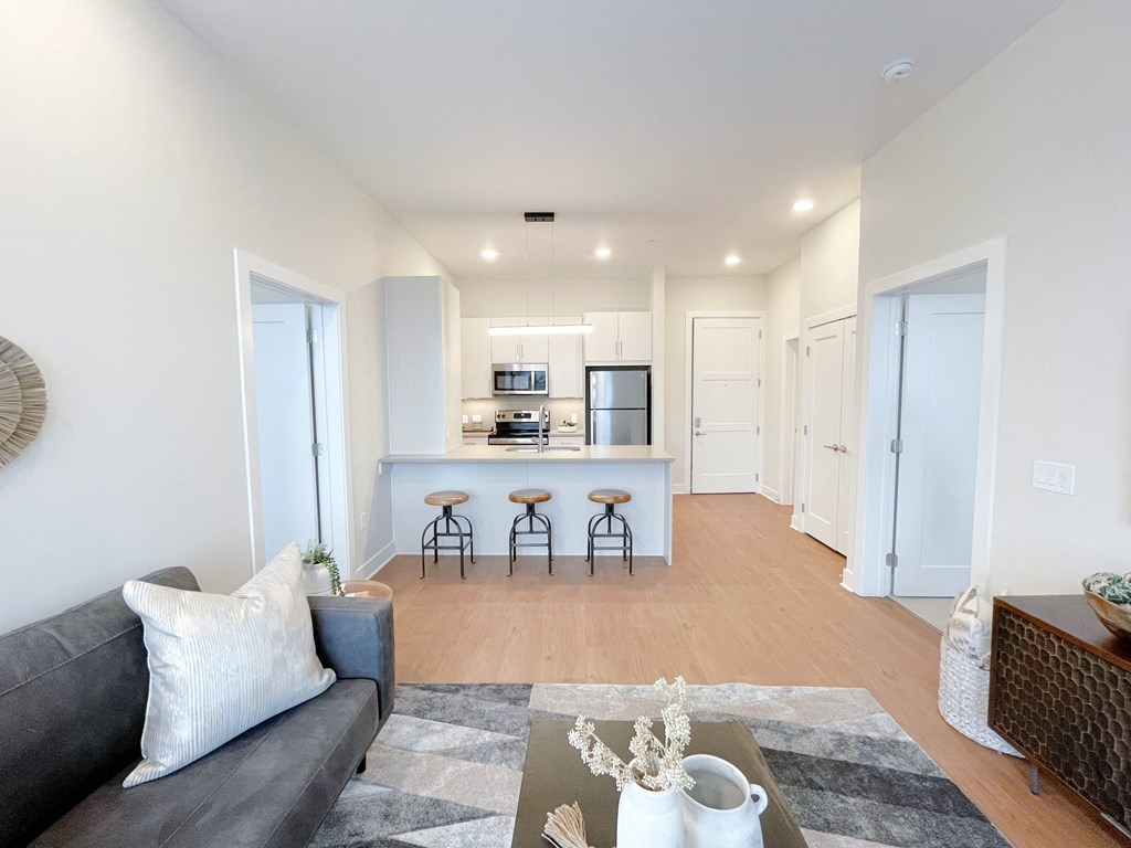 a living room with a couch and a kitchen in the background