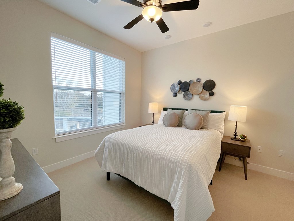 a bedroom with a large bed and a ceiling fan