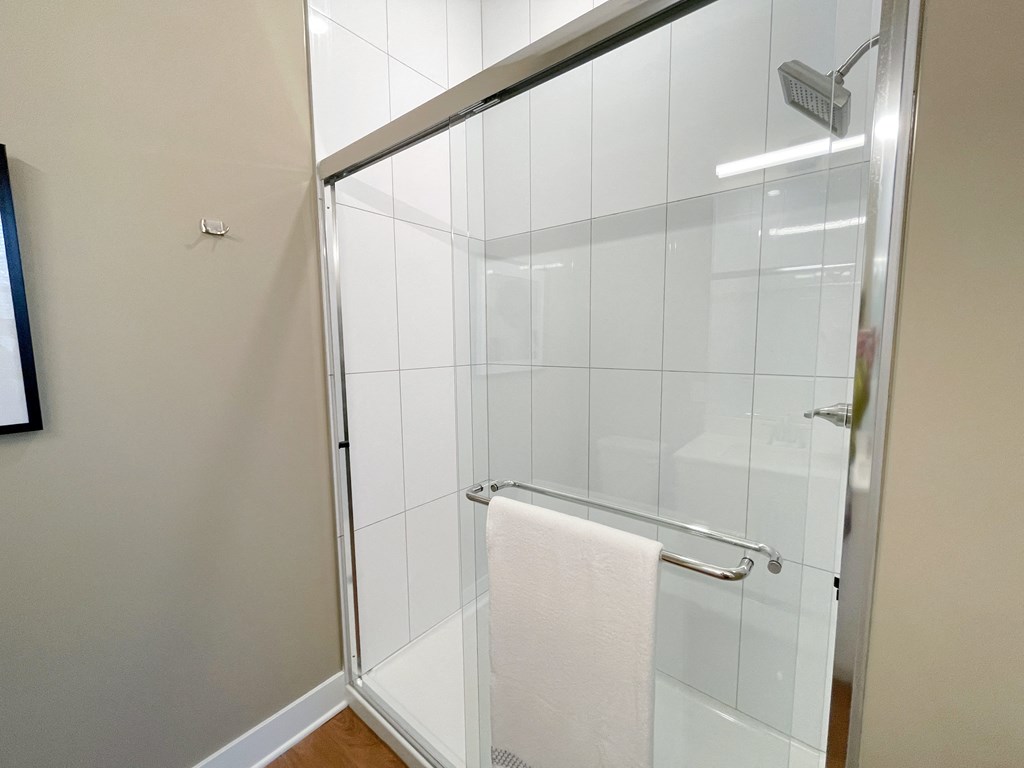 a small shower with a white towel in a bathroom