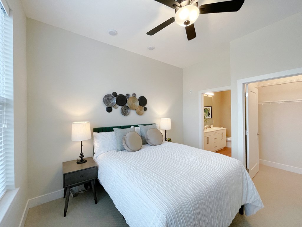 a bedroom with a large bed and a ceiling fan
