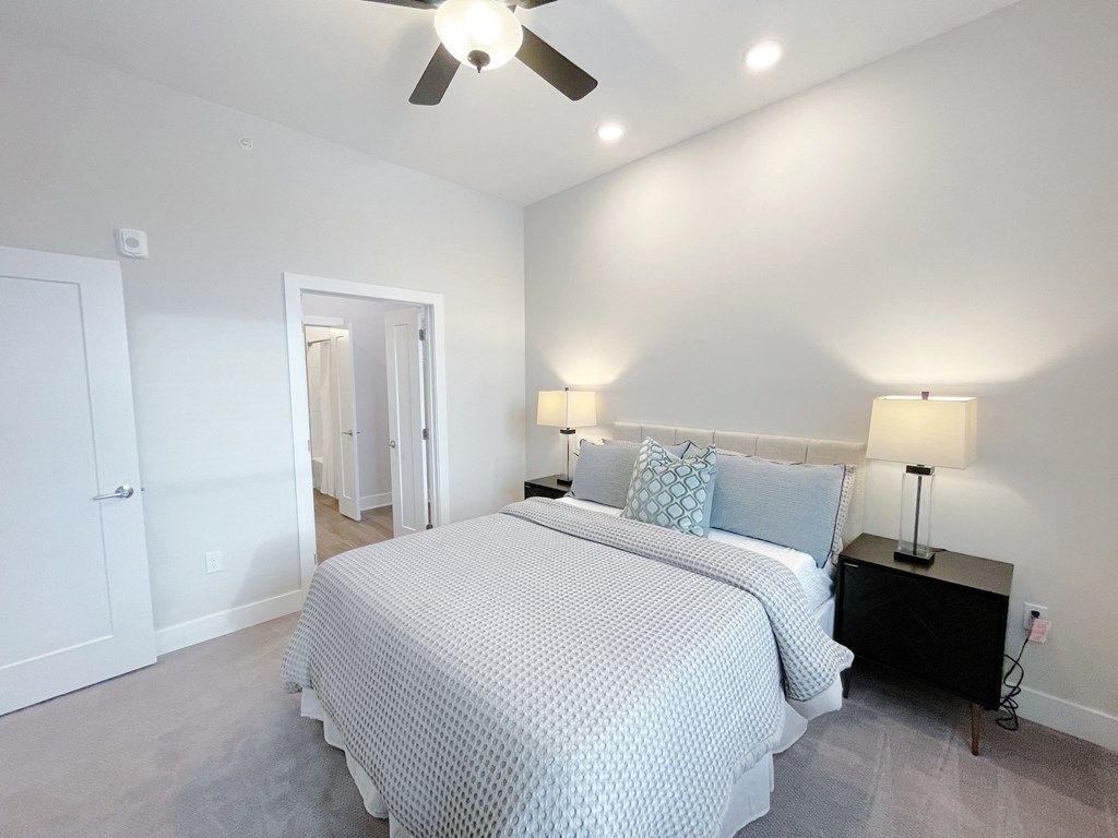 a bedroom with a bed and a ceiling fan