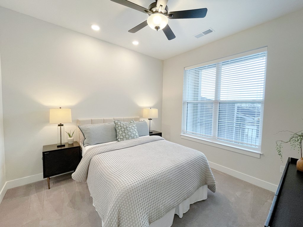 a bedroom with a bed and a ceiling fan
