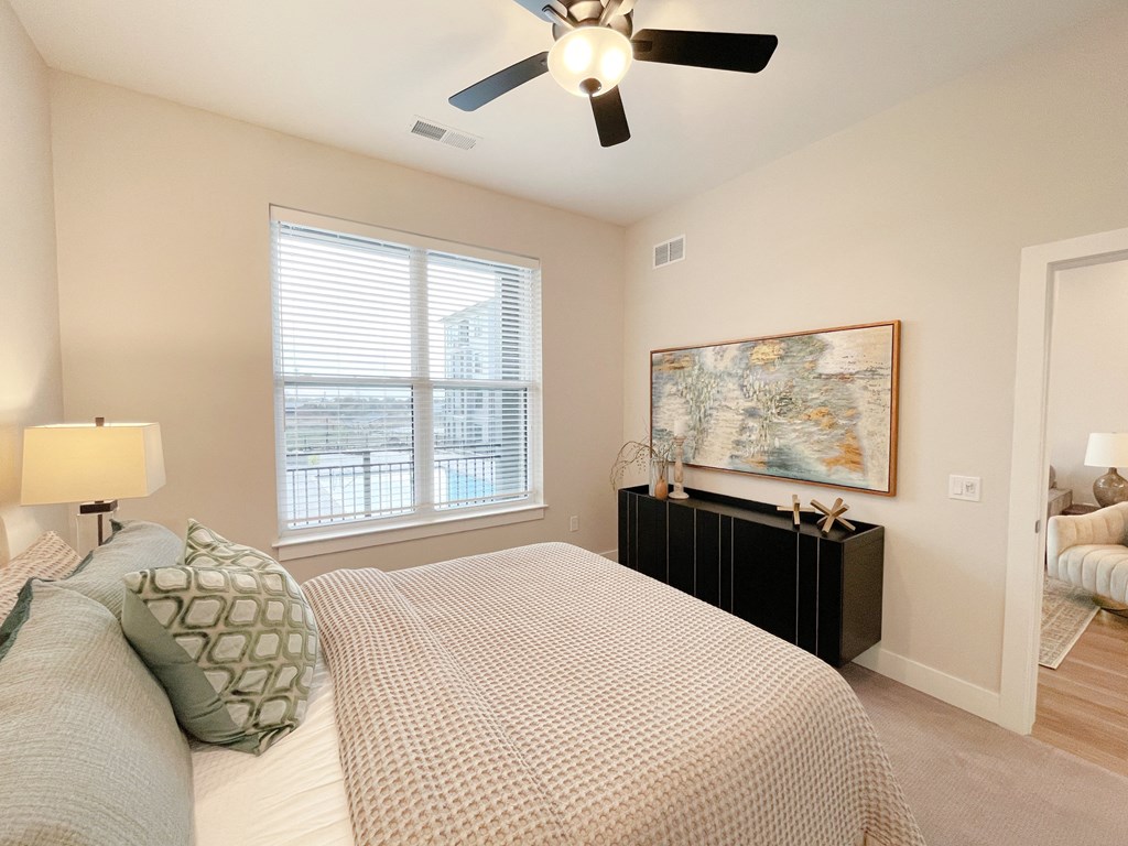 a bedroom with a large bed and a ceiling fan