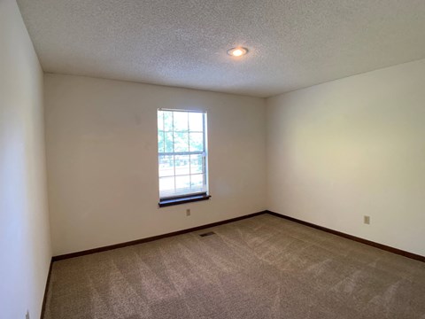 Large carpeted room with window