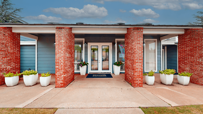 a house with blue siding and a white door with potted plants in front of it - Photo Gallery