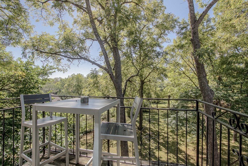 Photo of balcony with patio furniture and view of trees