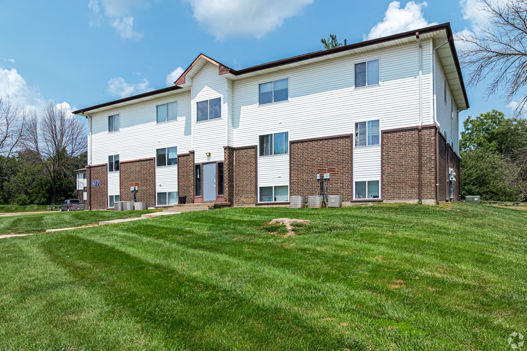 a large white building with a green lawn