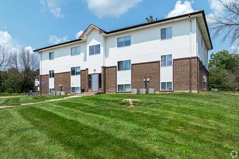 a large white building with a green lawn