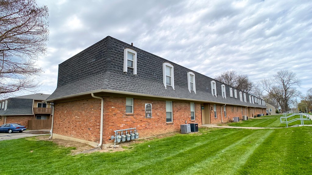 a large brick building with a black shingle roof