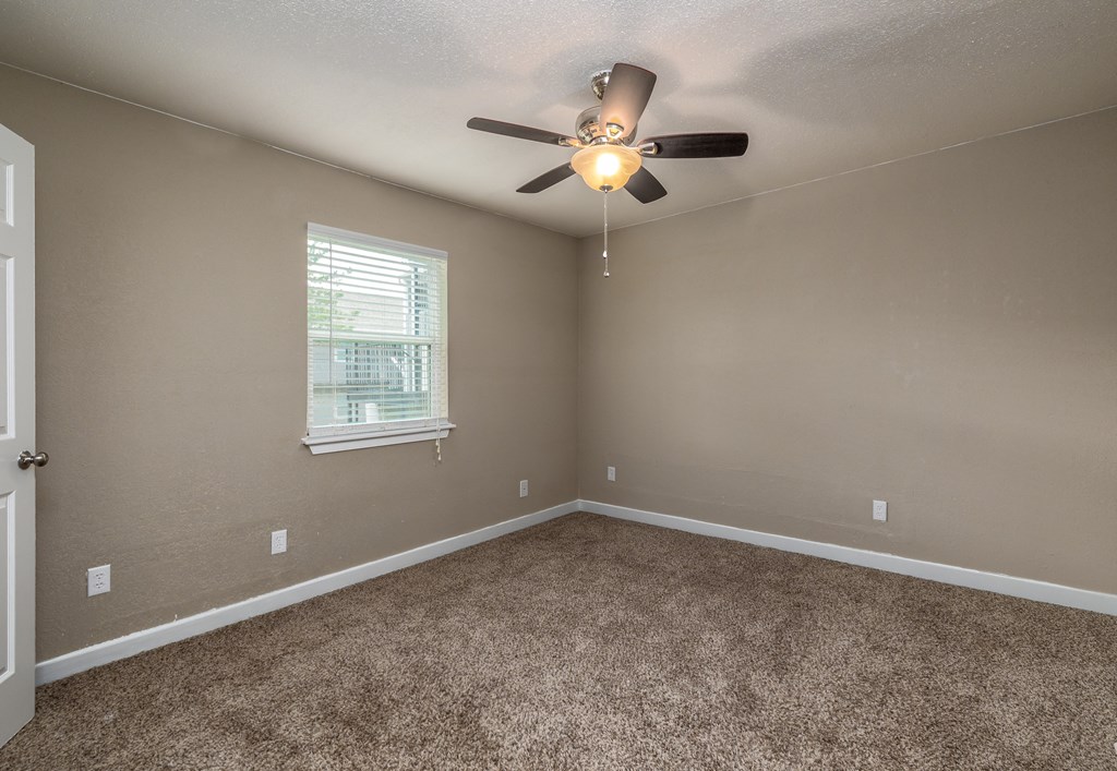an empty bedroom with a ceiling fan and a window at Residences at Lakeshore Apartments, Oklahoma City, OK, 73132