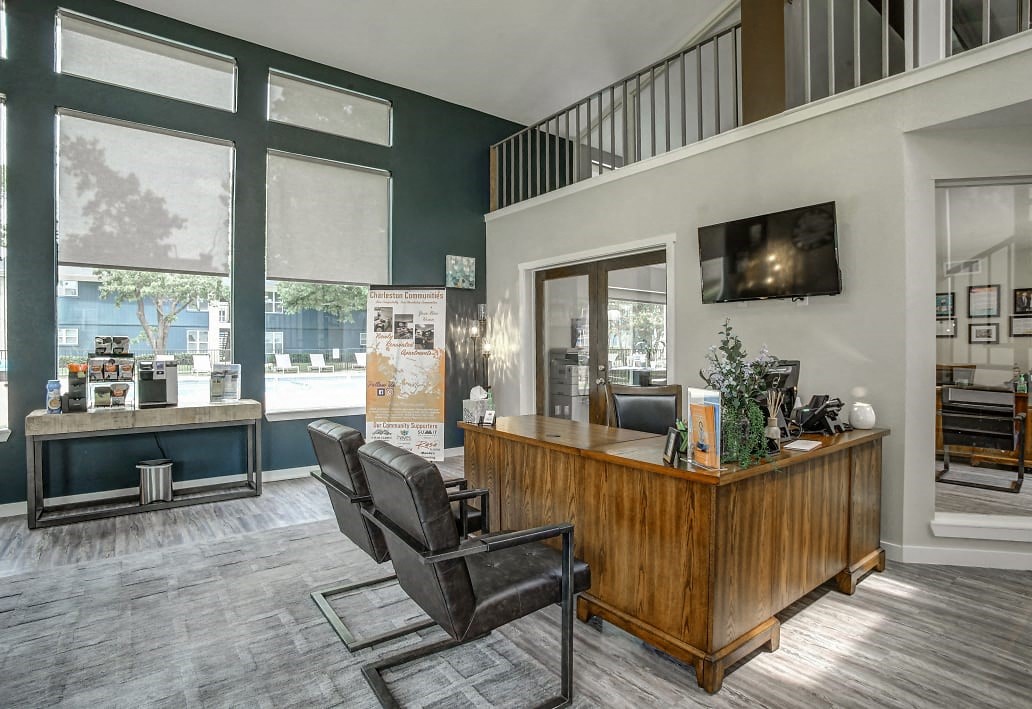 Leasing office with desk, chairs, and upstairs loft