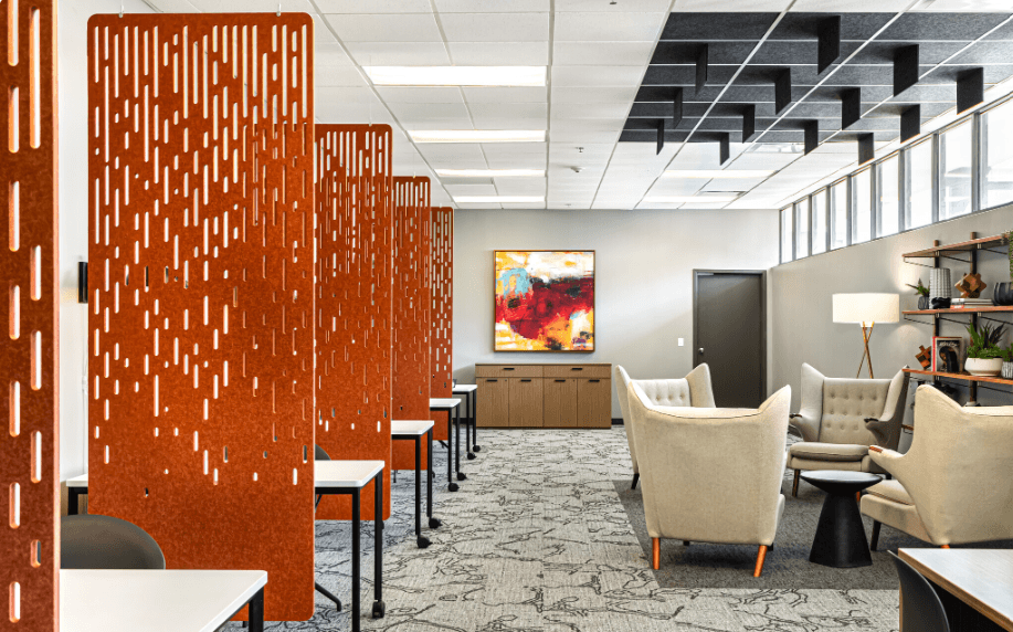 a lounge area with chairs and tables and a large orange divider
