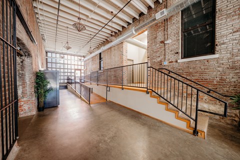 A large open space with a staircase and brick walls.
