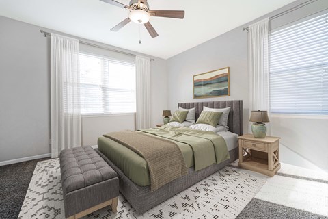 A bedroom with a large bed and a ceiling fan.