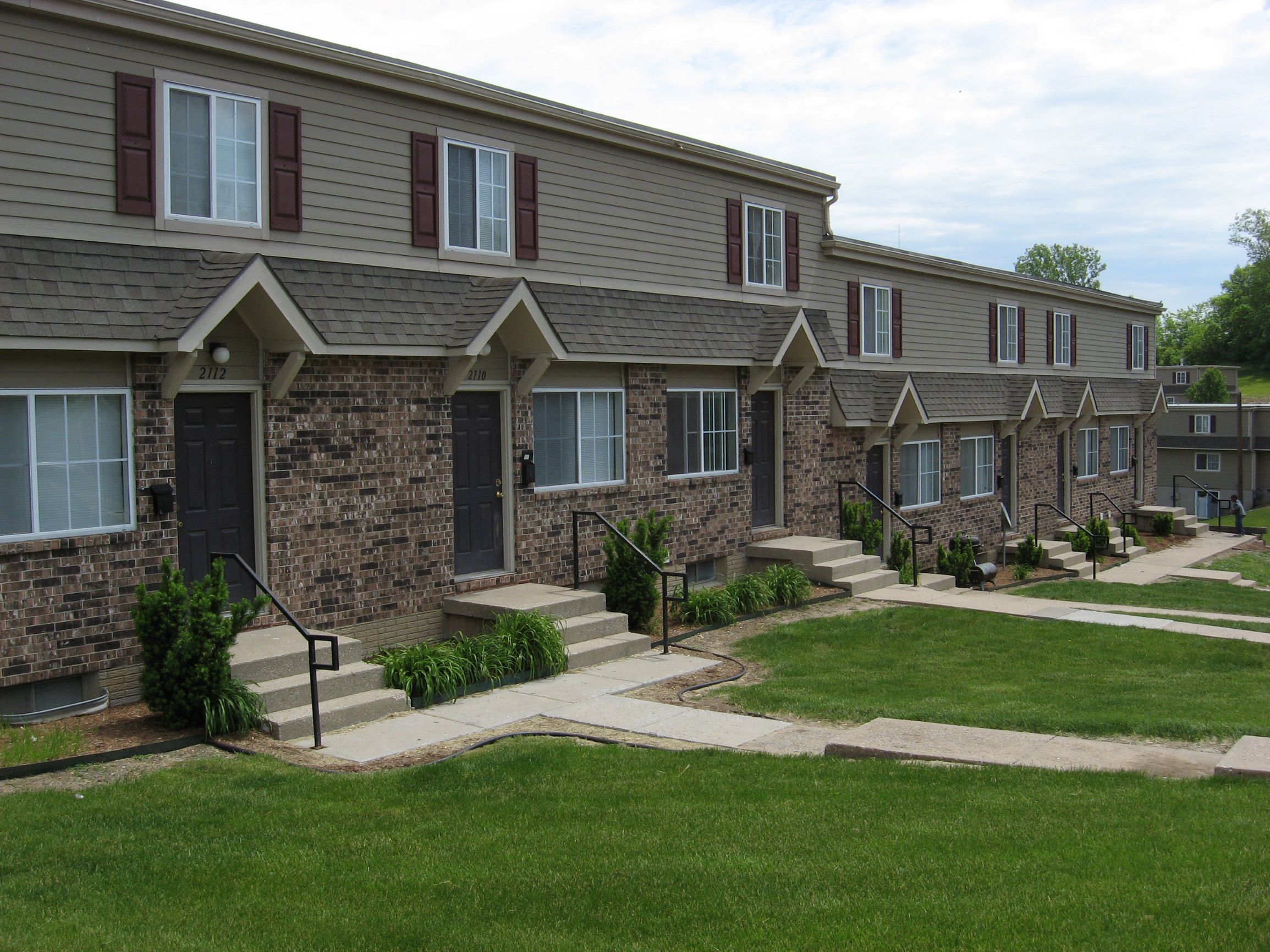 exterior of townhomes with green grass and concrete sidwalks