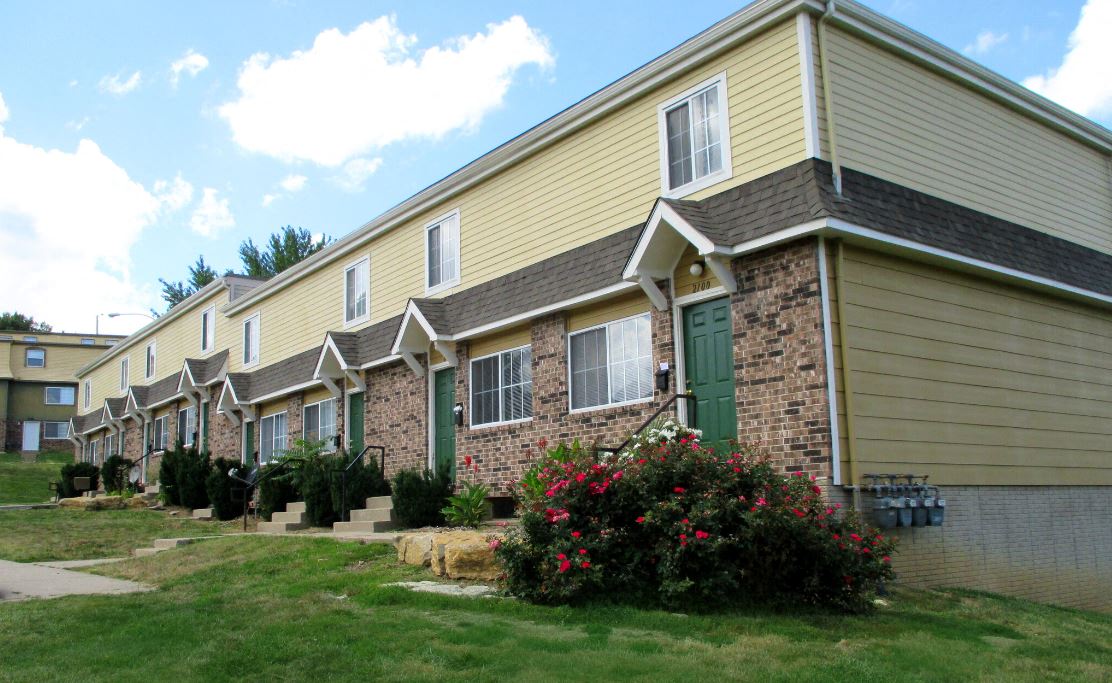 tan exterior of town homes with shrubbery out front