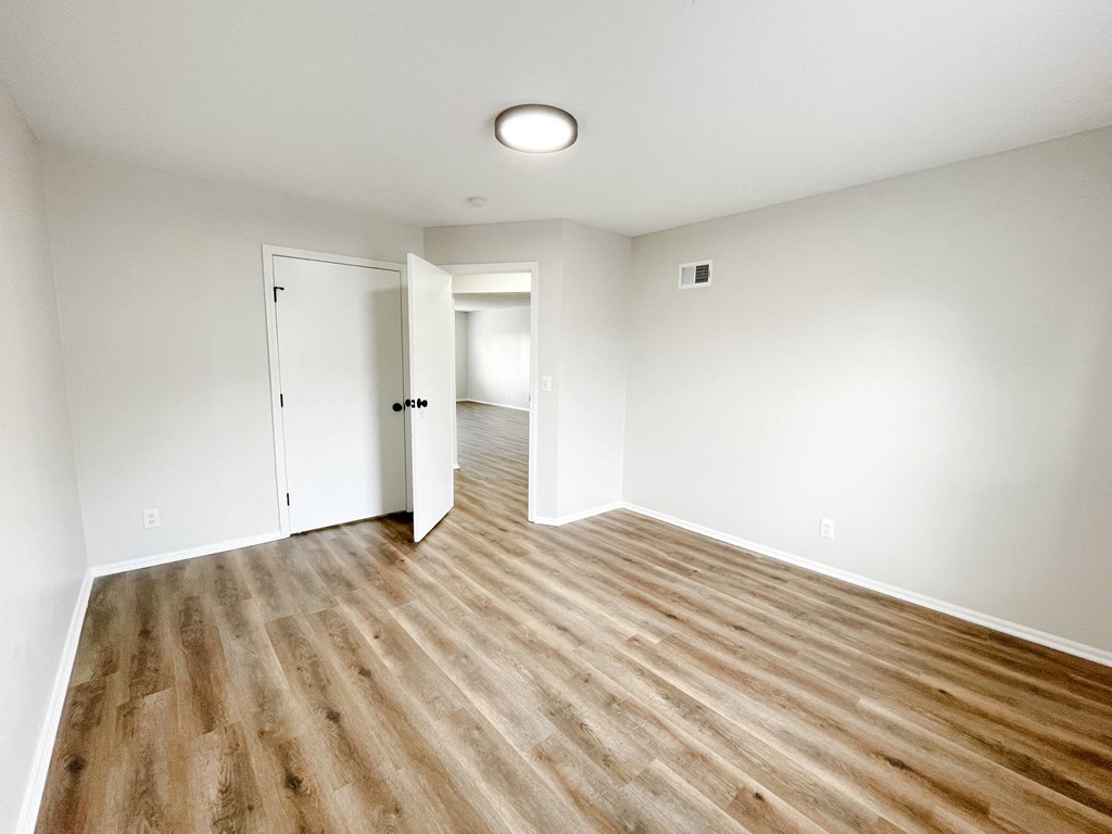 an empty living room with white walls and wood flooring