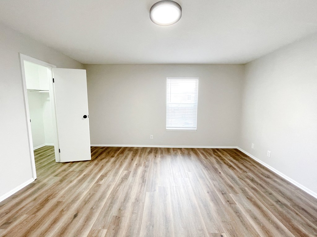 an empty living room with wood flooring and white walls