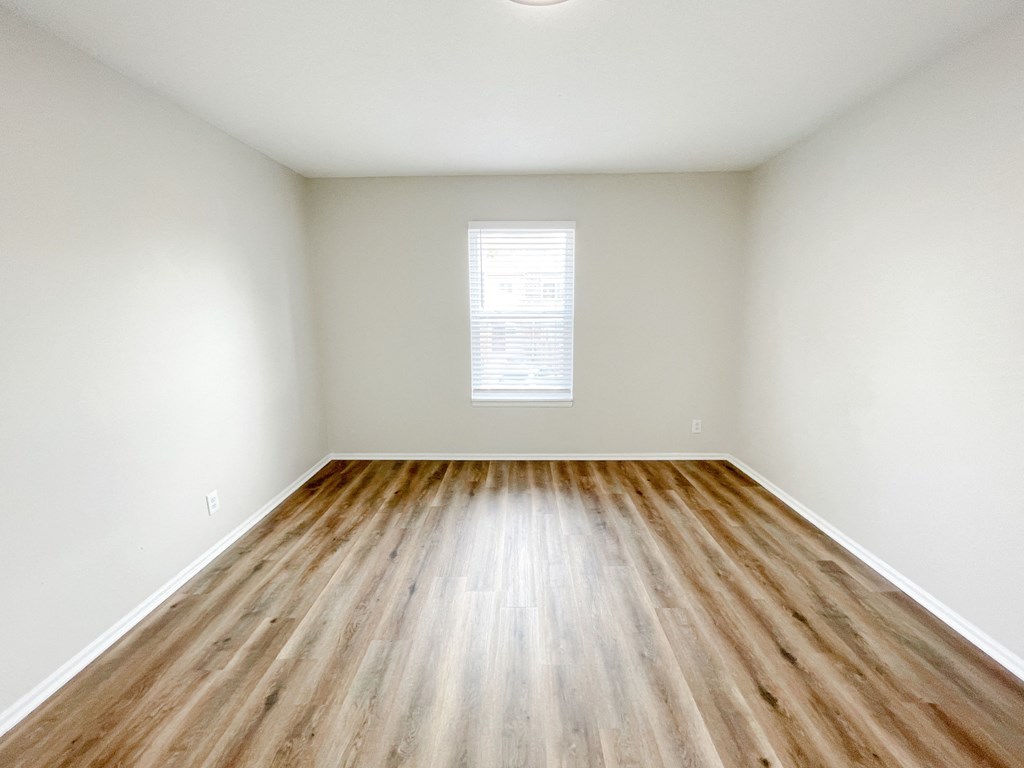 an empty living room with white walls and wood flooring