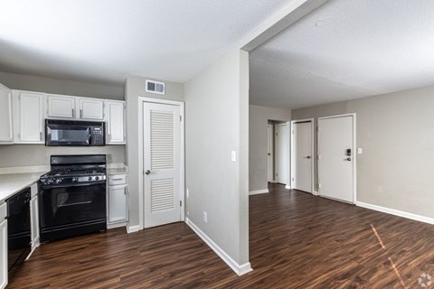 A kitchen with white cabinets and a black stove top oven.