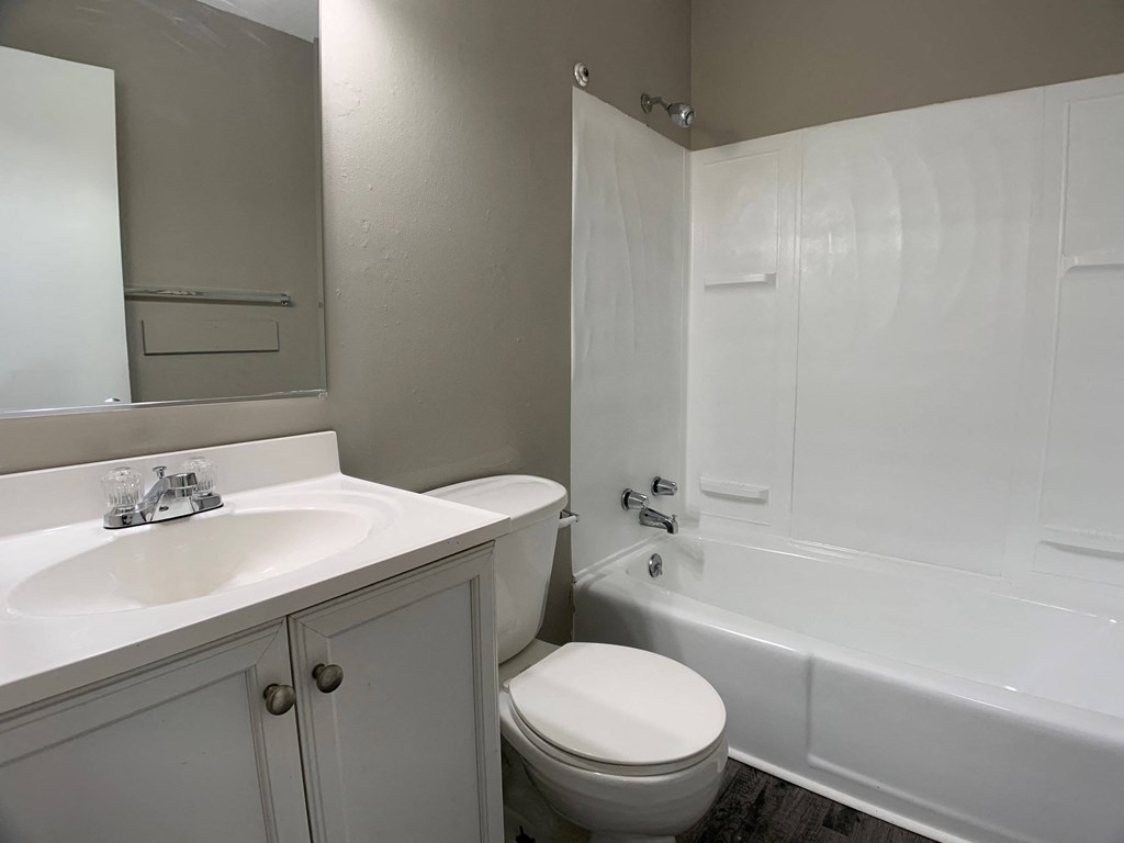 bathroom with toilet, vanity, and full tub