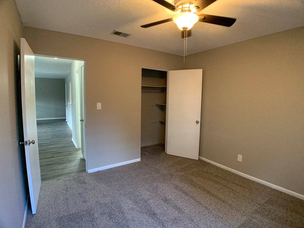 carpeted bedroom with large closet and ceiling fan
