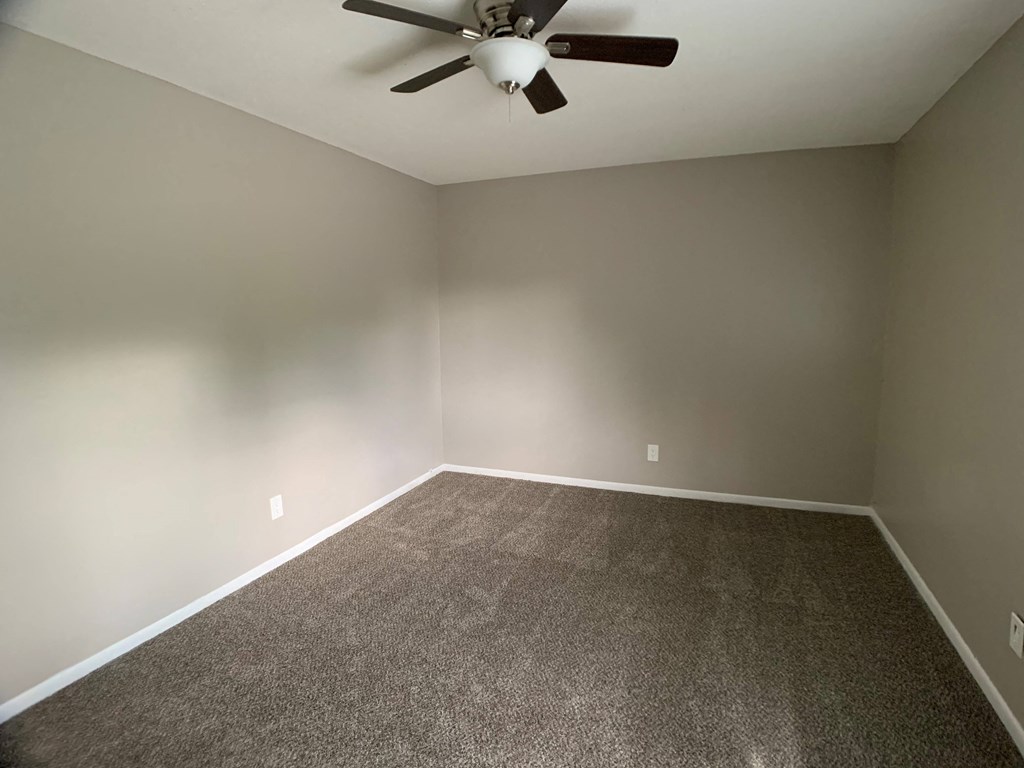 carpeted bedroom with large closet and ceiling fan