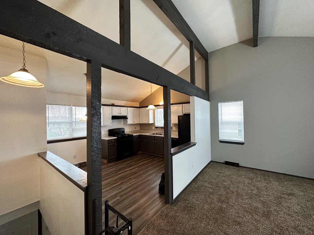 the view from the living room into the kitchen and dining room