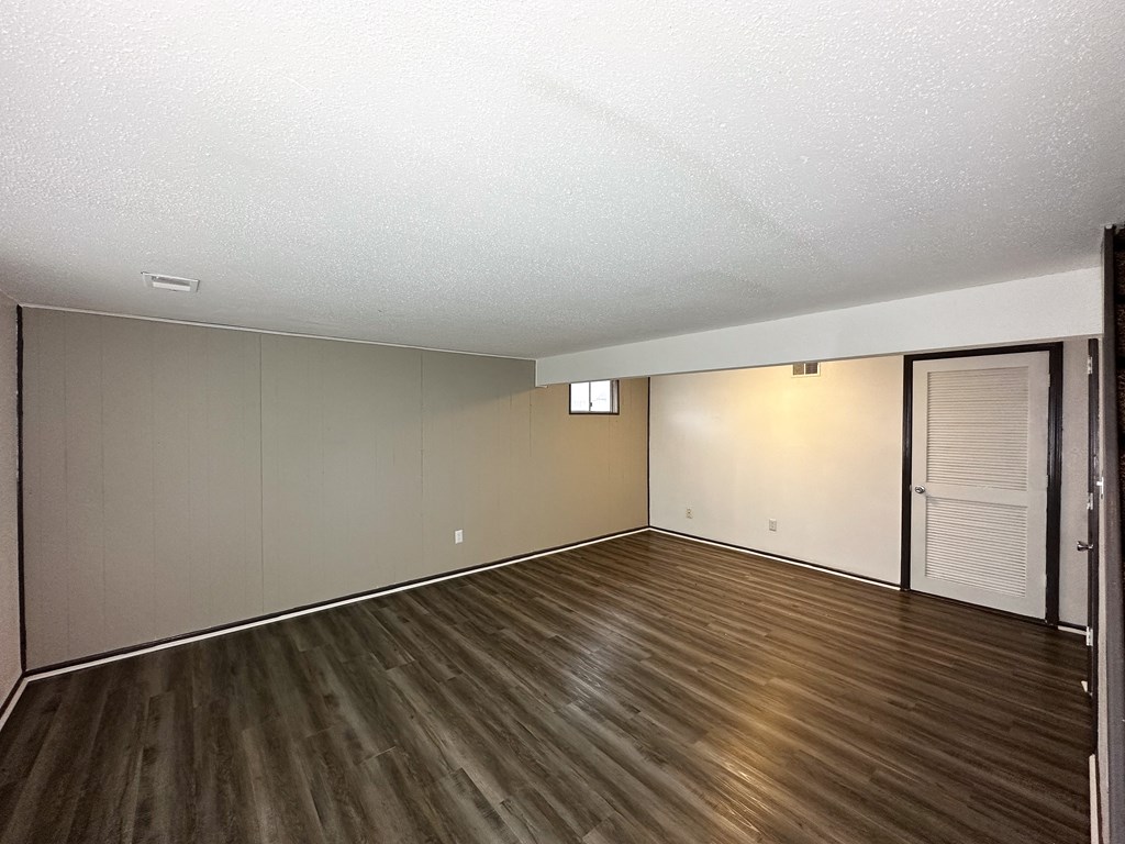 an empty living room with wood flooring and sliding glass doors
