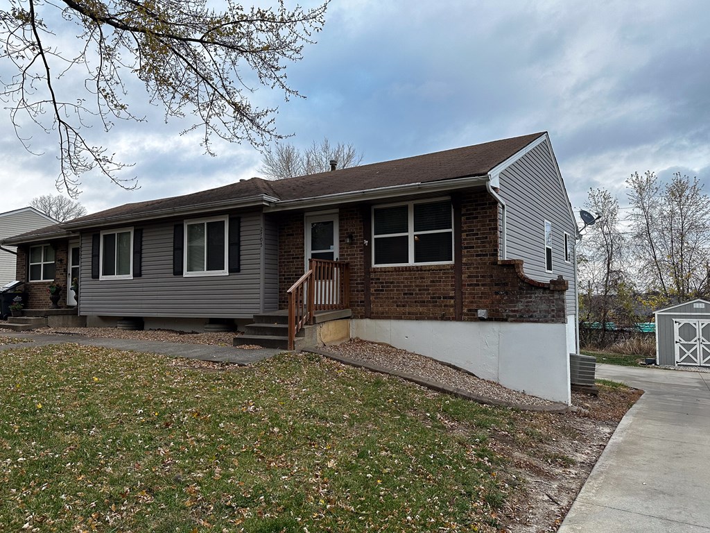 a gray house with a front porch and a sidewalk
