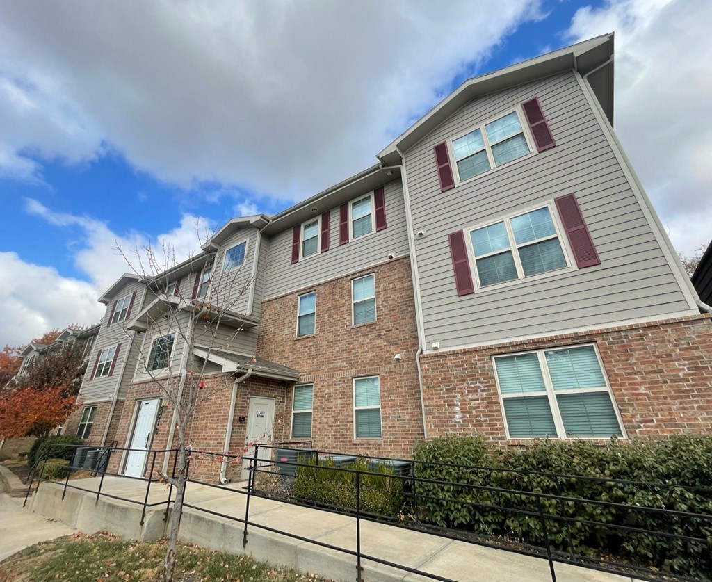 A two-story house with a grey and red exterior.