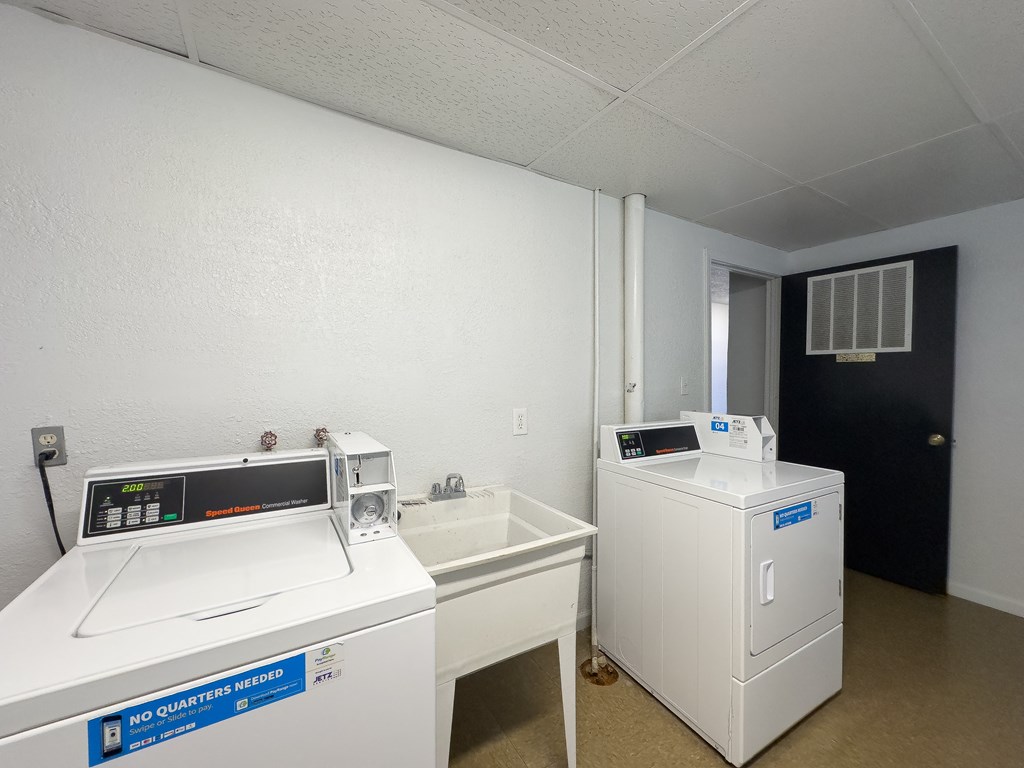 a laundry room with two washing machines and a sink