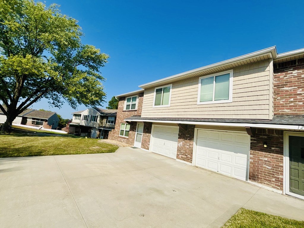A residential building with a tree in front of it.