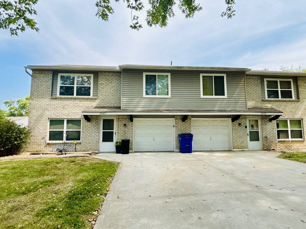 A two-story house with a garage and a driveway.