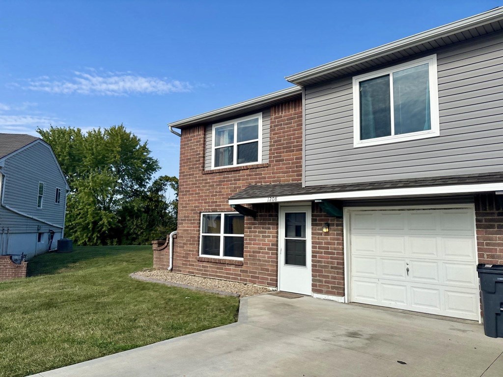A house with a grey roof and a white garage door.