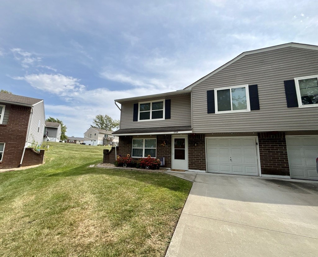 A house with a grey roof and a white garage door.