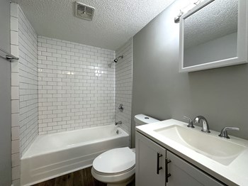 Updated bathroom with subway tile in the shower at  the 1 twenty two at 63rd apartments - Photo Gallery 8