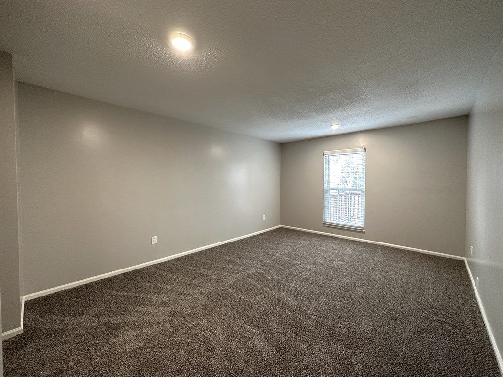 an empty room with carpet and a window