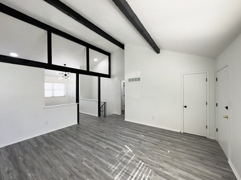 the living room of a new home with white walls and wood flooring