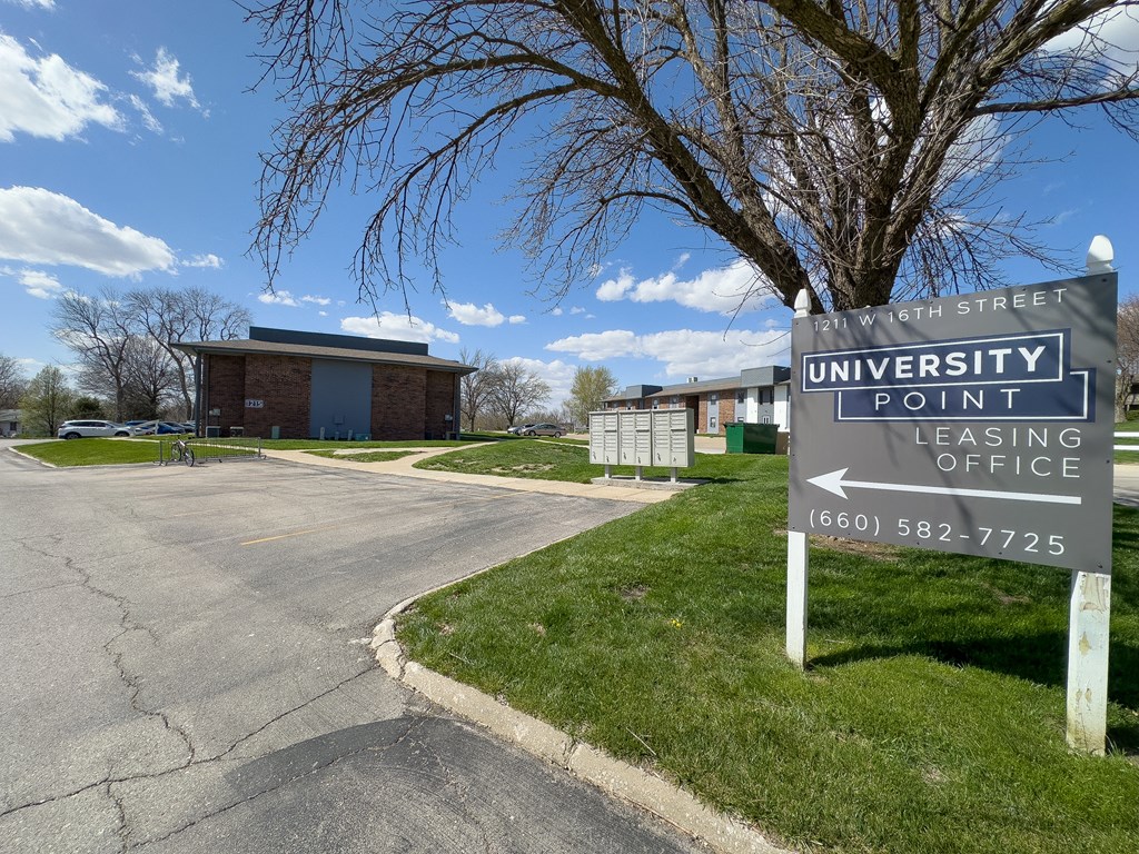 a sign for the university pointe leasing office in front of a building