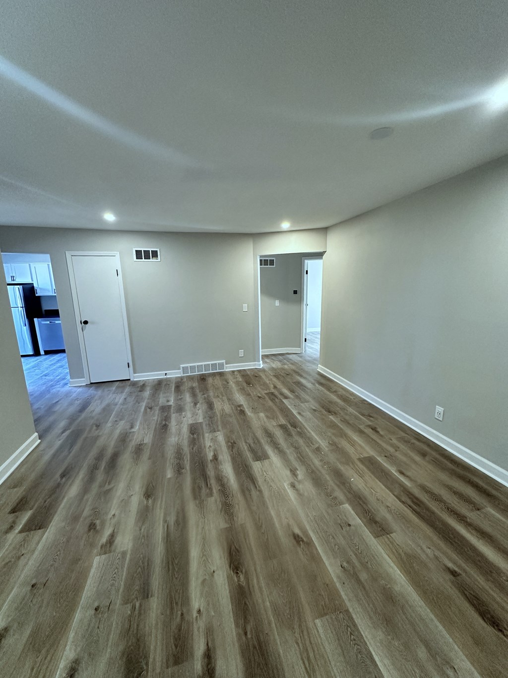 a living room with wooden floors and white walls