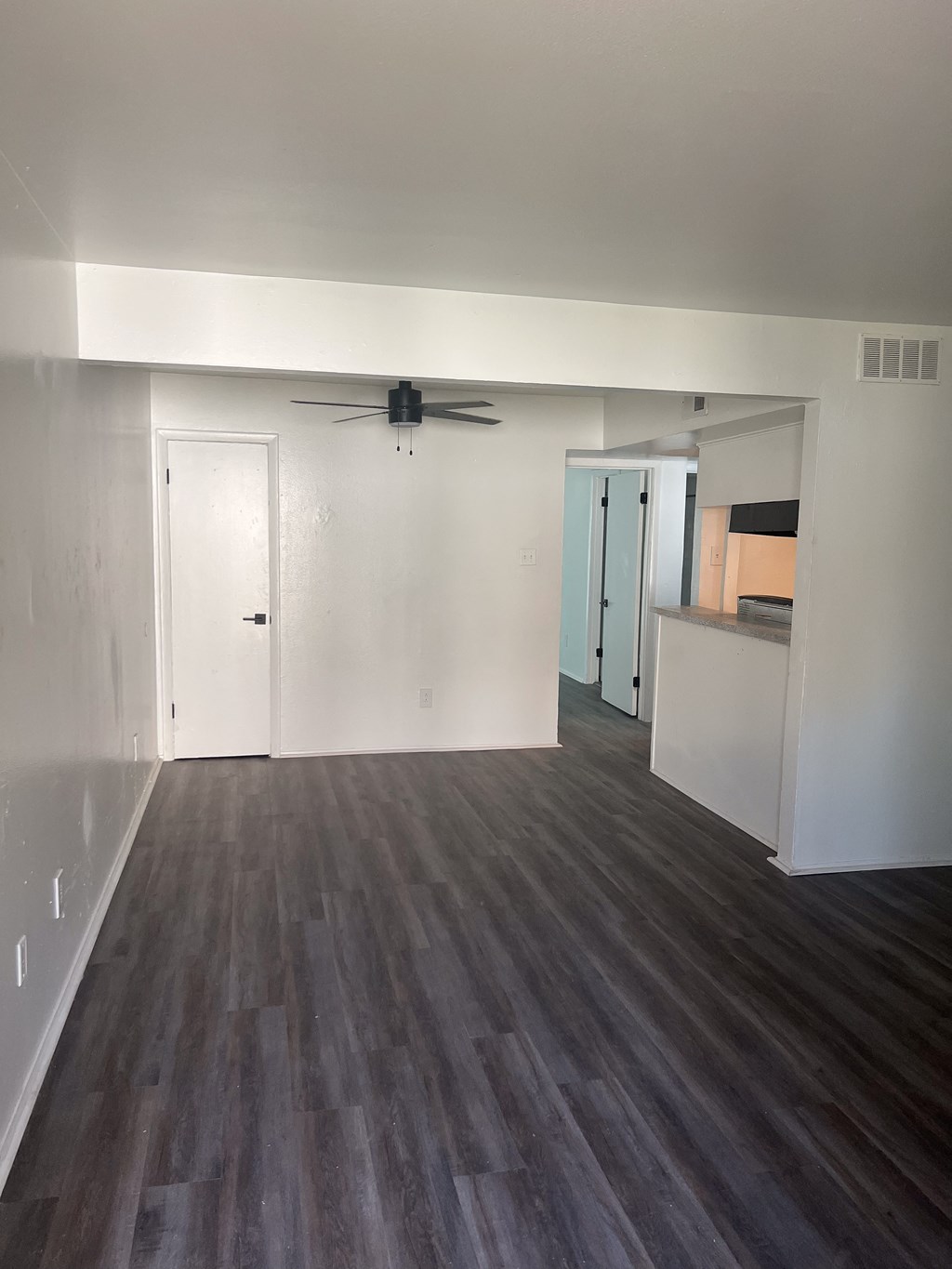 an empty living room with white walls and wooden floors