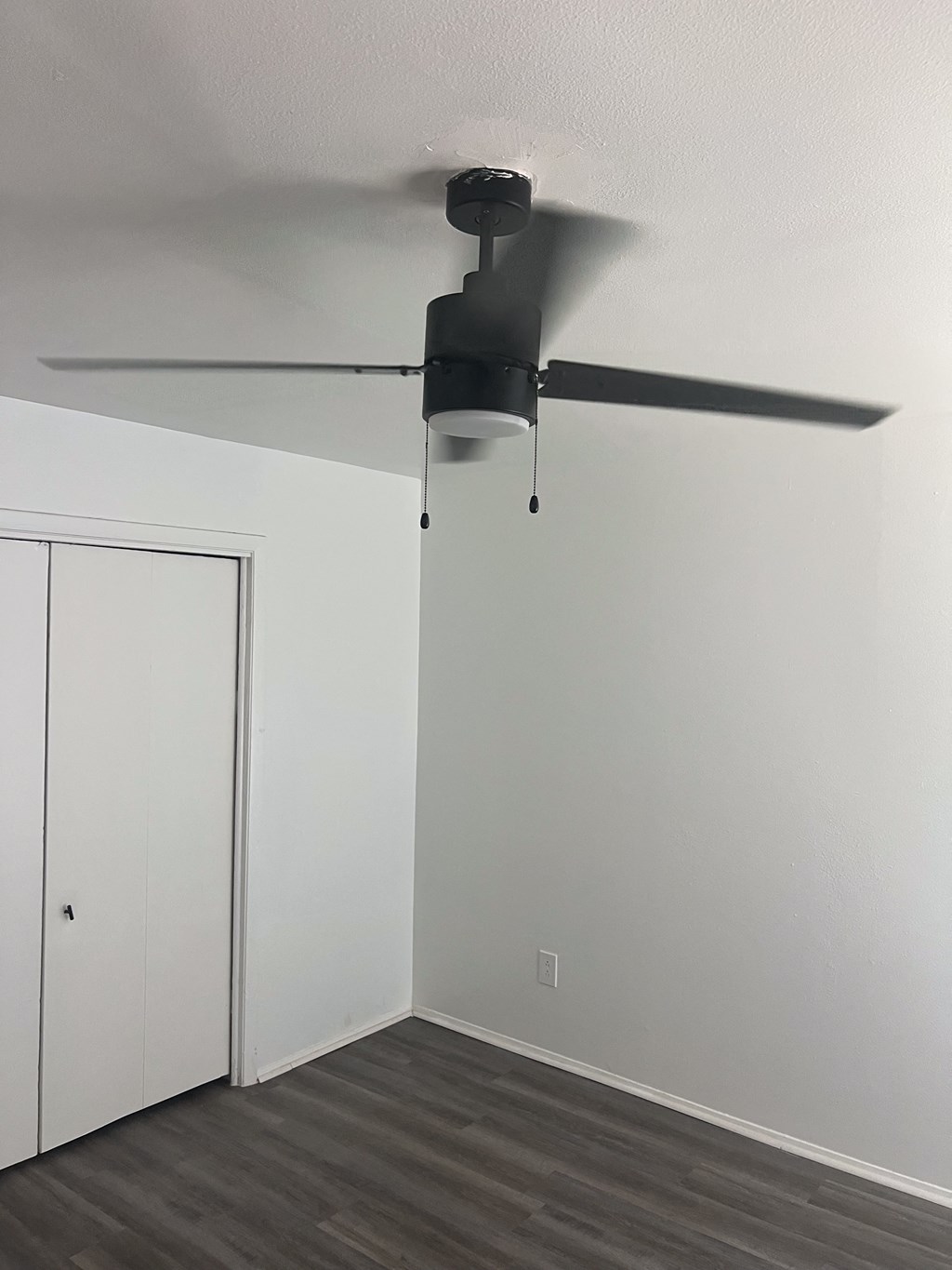 an empty room with a ceiling fan and a closet