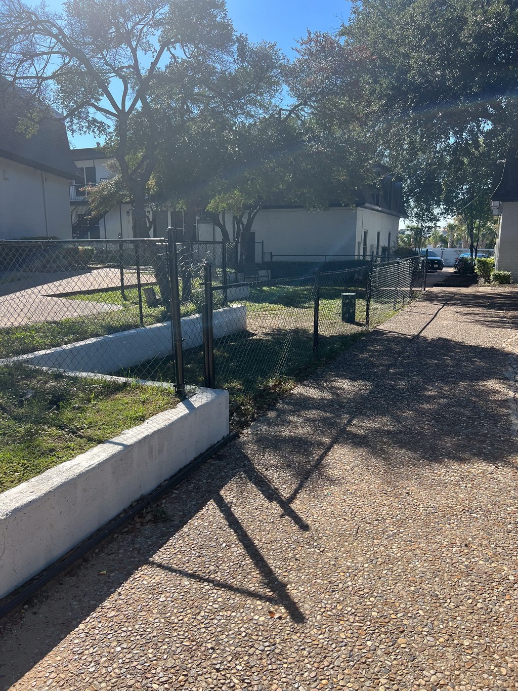 a fenced in yard with a chain link fence and a house in the background